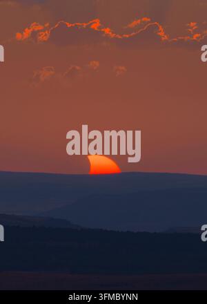 Admirez la beauté du soleil partiellement masqué lors d'une éclipse solaire époustouflante en Espagne, projetant une lueur envoûtante au coucher du soleil Banque D'Images