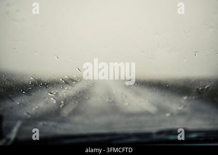 Vue à travers le pare-brise d'une voiture par un jour de pluie Banque D'Images