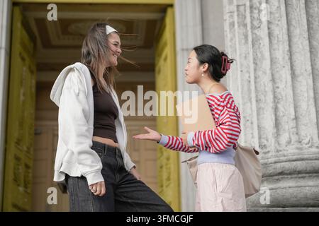 Des étudiants divers discutant à l'entrée d'un bâtiment du campus Banque D'Images