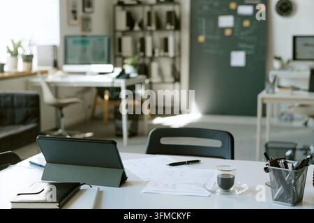 Tablette numérique et tasse de café sur un bureau dans un bureau moderne Banque D'Images