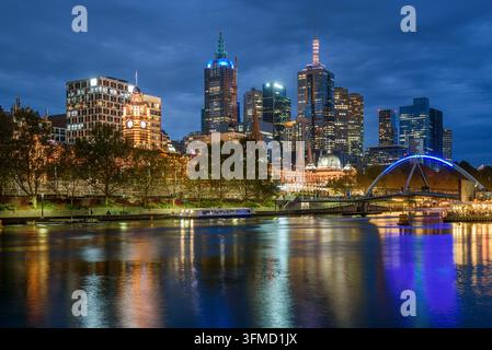 Centre-ville illuminé de Melborne vu depuis la rive sud de la rivière Yarra au crépuscule en automne. Réflexion dans l'eau. Banque D'Images