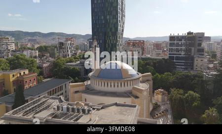 Vue aérienne de la cathédrale orthodoxe de la Résurrection avec son dôme bleu distinctif, entourée de gratte-ciel modernes et d'arbres verts luxuriants dans Banque D'Images
