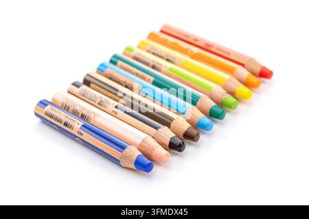 Des crayons en bois de différentes couleurs sont alignés sur un fond blanc Banque D'Images