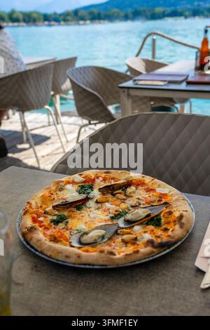 Pizza aux fruits de mer servie au bord du lac de Worthersee en Carinthie, Autriche Banque D'Images
