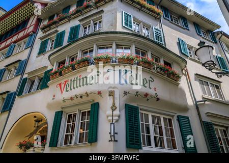 Zurich, Suisse - 28 juin 2024 : Façade historique du restaurant Veltliner Keller avec une fenêtre en échauguette ornée, des fleurs de géranium rouges et des volets verts Banque D'Images
