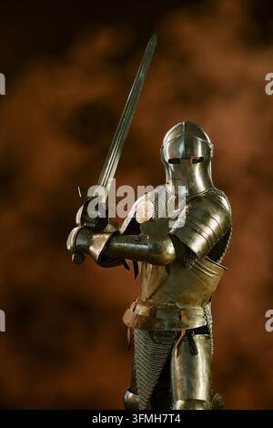 Chevalier médiéval en armure complète tenant une épée prête pour la bataille Banque D'Images