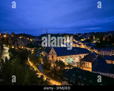 Paysage urbain européen avec église historique et bâtiments illuminés à l'heure bleue du crépuscule. Vue en hauteur d'une ville historique européenne au crépuscule feat Banque D'Images
