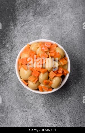 Petits champignons entiers en conserve dans l'huile avec des morceaux de carotte, du sel et des épices. Champignons en conserve comme fond alimentaire pour votre conception Banque D'Images