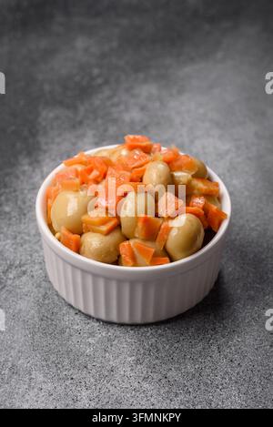 Petits champignons entiers en conserve dans l'huile avec des morceaux de carotte, du sel et des épices. Champignons en conserve comme fond alimentaire pour votre conception Banque D'Images