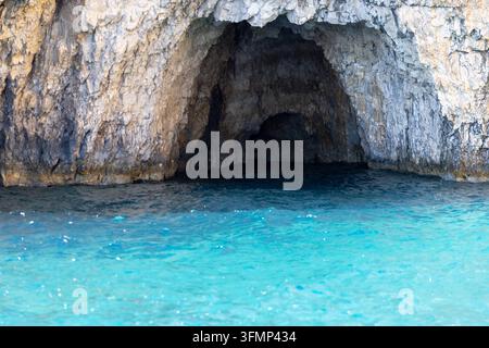 Grande grotte marine naturelle creusée dans des falaises de calcaire escarpées aux grottes de Keri à Zakynthos, Grèce, avec une eau turquoise claire de la mer Ionienne à l'entrée un Banque D'Images