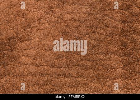 Photographie macro d'une véritable surface en daim marron présentant une texture douce et veloutée et des tons chauds et riches sous un éclairage diffus doux. Banque D'Images
