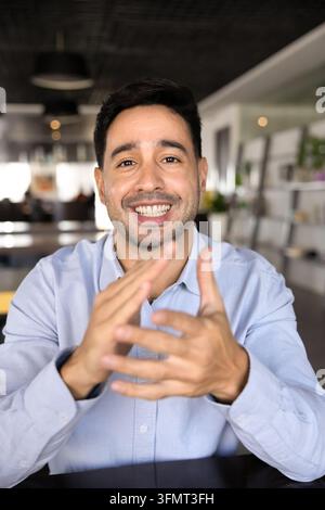 Vue webcam d'un homme hispanique souriant en train de passer un appel vidéo Banque D'Images