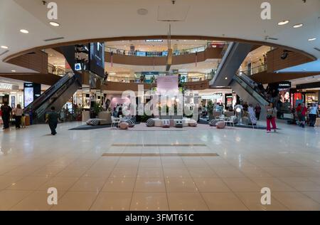 Atrium central du centre commercial Gurney Plaza, avec des vitrines de magasins, des clients et des escaliers mécaniques qui se croisent à Penang, en Malaisie, pris en 2026 Banque D'Images