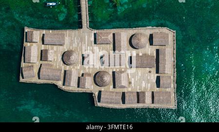 Une vue aérienne montre des maisons sur pilotis préhistoriques reconstituées disposées sur une plateforme en bois au-dessus du lac Ohrid. Banque D'Images