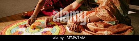 Femmes indiennes décorant le sol pour la célébration traditionnelle de Diwali Banque D'Images