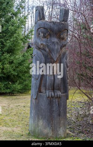 Vue d'un poteau totémique en bois patiné aux sculptures complexes au camping de Ksan à Ksan, Colombie-Britannique, Canada. Banque D'Images