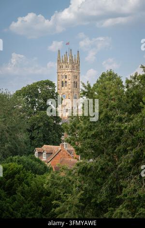 La tour de l'église St Mary, Warwick, Royaume-Uni. Vue depuis les remparts du château de Warwick avec des arbres au premier plan. Banque D'Images