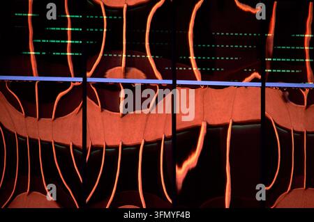 Composition abstraite de lignes ondulées orange lumineuses traversant une grille sombre avec des marques de données numériques vertes subtiles, créant un arrière-plan technologique futuriste Banque D'Images