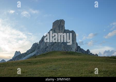 Sommet rocheux dramatique s'élevant au-dessus d'une prairie alpine sous un ciel bleu du soir Banque D'Images