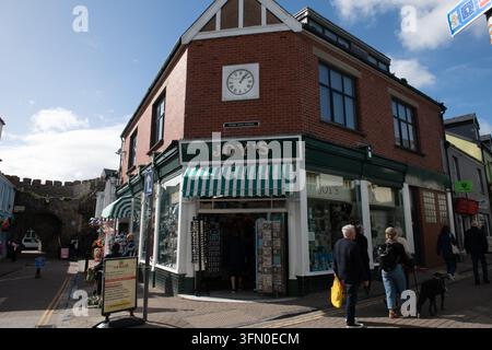 Vue d'angle de la boutique de cadeaux de Joy sur Upper Frog Street avec façade horloge et des clients près des remparts médiévaux à Tenby, Pembrokeshire, Pays de Galles. Banque D'Images