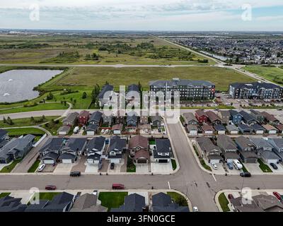 Vue aérienne montrant des maisons modernes à Martensville, Saskatchewan. Le quartier comprend des pelouses bien entretenues, des voitures garées et des routes pavées. L'arrière-plan révèle un paysage ouvert Banque D'Images