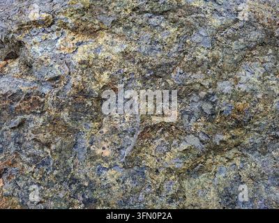 Photographie en gros plan détaillée capturant la texture rugueuse et usée de la surface d'une formation rocheuse ou de pierre naturelle Banque D'Images