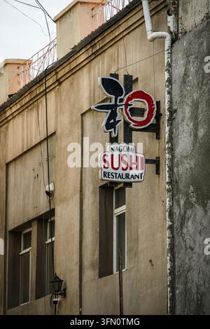 Oulan-Bator, Mongolie – 03 septembre 2017 : Un cliché vertical de l’extérieur du restaurant Nagomi Sushi avec deux panneaux sur une façade de bâtiment beige ; le Banque D'Images