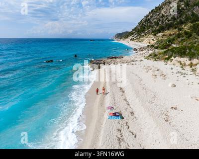 Des moments de détente se déroulent sur la plage de Gaidaros à Lefkada, en Grèce, où les baigneurs profitent des sables doux et des vagues vibrantes. Une destination pittoresque dans les îles ioniennes attend votre découverte. Banque D'Images