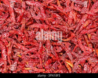 Pile de piments rouges séchés sur un marché mexicain – Texture de fond pour ingrédient alimentaire épicé Banque D'Images
