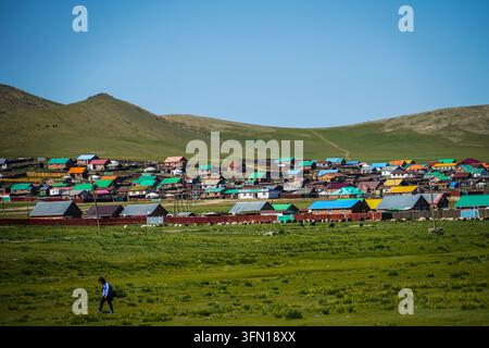 Une prise aérienne grand angle capture un village mongol étendu comportant de nombreuses maisons aux toits aux couleurs vives, dont bleu, orange, vert Banque D'Images