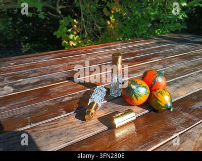 Bouteilles de parfum en verre décoratives avec des citrouilles colorées sur une table en bois rustique Banque D'Images