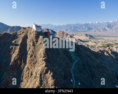 Vue aérienne du palais de Leh perché sur une crête montagneuse rocheuse avec un sentier sinueux et des vues panoramiques sur l'Himalaya à Leh, Ladakh, en Inde. Banque D'Images