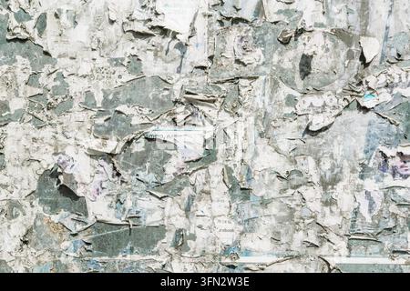 Texture de papier déchiré et crasseux, mur d'affiches de rue patiné, fond de tableau d'affichage usé. Photo de haute qualité Banque D'Images