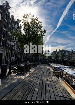 Bateaux de visite des canaux amarrés le long d'une promenade en bois le long de l'Herengracht au centre d'Amsterdam, Pays-Bas Banque D'Images