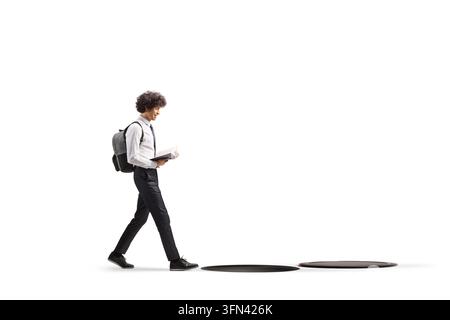 Jeune homme marchant et lisant un livre en direction d'un puits ouvert isolé sur fond blanc Banque D'Images