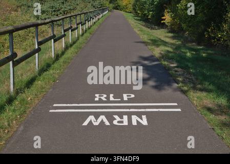 Frontière entre les Länder allemands de Rhénanie-du-Nord-Westphalie et de Rhénanie-Palatinat, représentée sur un chemin cyclable près de Kronenburg Banque D'Images