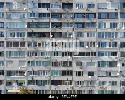 Vue aérienne d'une façade de bloc d'appartements répétitive de l'ère socialiste avec de nombreux balcons, antennes paraboliques et unités de climatisation à Sofia, Sofia Banque D'Images