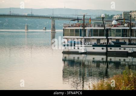Vue des bateaux de croisière fluviale amarrés sur le Danube avec le pont Varadin en arrière-plan à Novi Sad, Vojvodina, Serbie. Banque D'Images