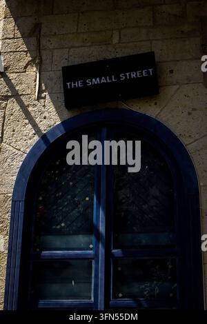 Entrée voûtée avec le panneau The Small Street sur un bâtiment en pierre à Alacati, Turquie Banque D'Images
