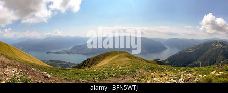 Vue panoramique large à angle élevé du lac de Côme et de ses bras, vue depuis les crêtes herbeuses du mont Crocione. Le paysage présente des montagnes majestueuses Banque D'Images