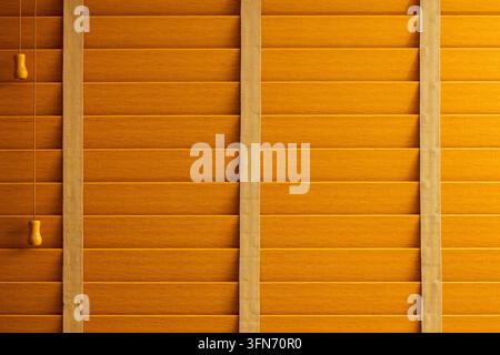 gros plan de lattes de store en bois chaud et de rubans de tissu verticaux créant un motif géométrique répétitif dans la lumière dorée d'une lampe. Banque D'Images