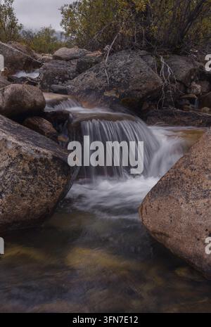 Un petit ruisseau de montagne cascade sur des rochers et des blocs dans le parc territorial de Tombstone, Yukon, Canada, entouré par la nature sauvage du Nord. Banque D'Images