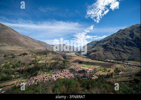 Une vue panoramique d"un village de vallée rurale péruvien entouré par les montagnes des Andes, des terres agricoles en mosaïque et un ciel bleu clair. Paysage de hautes terres serein sh Banque D'Images