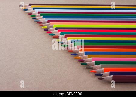 Crayons de couleur colorés sur un fond marron, dessin, créativité, papeterie, concepts d'éducation et de fournitures scolaires. Banque D'Images