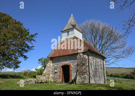 L'église historique de Lullington du XIIIe siècle, connue comme la plus petite église du Sussex, se dressant sous un ciel bleu clair dans les South Downs. Banque D'Images