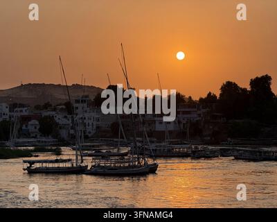 Felucca naviguant sur le Nil au coucher du soleil, photographié sur le fleuve Nil à Assouan dans le sud de l'Égypte. Banque D'Images