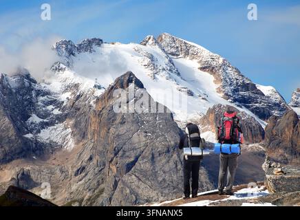 Vue du mont Marmolada avec deux touristes randonneurs grimpeurs et de beaux nuages dans le ciel, le plus haut sommet des Alpes Dolomites, Italie Banque D'Images