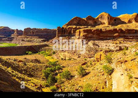 Les voies ferrées longeent des falaises de grès accidentées près du point de départ pittoresque du sentier Corona Arch à l'extérieur de Moab, Utah Banque D'Images