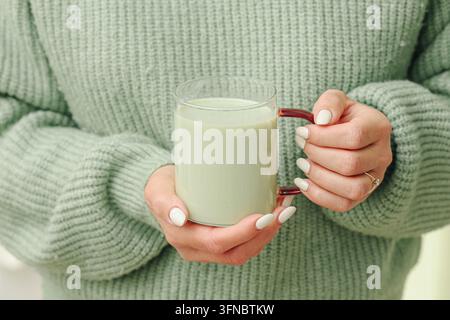 Femme tenant une tasse de thé vert matcha dans les deux mains. Fond matcha pour boisson saine thé japonais bien-être antioxydants et nutrition quotidienne. Banque D'Images