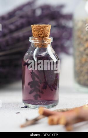 Eau de lavande dans une petite bouteille en verre avec bouchon sur une table avec lavande Banque D'Images
